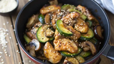 chicken with zucchini and mushrooms in a cast iron skillet