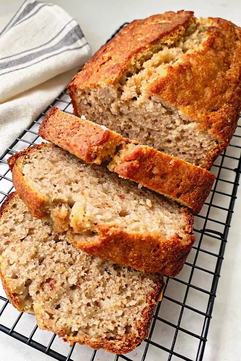sliced cottage cheese banana bread resting on a cooling rack for serving