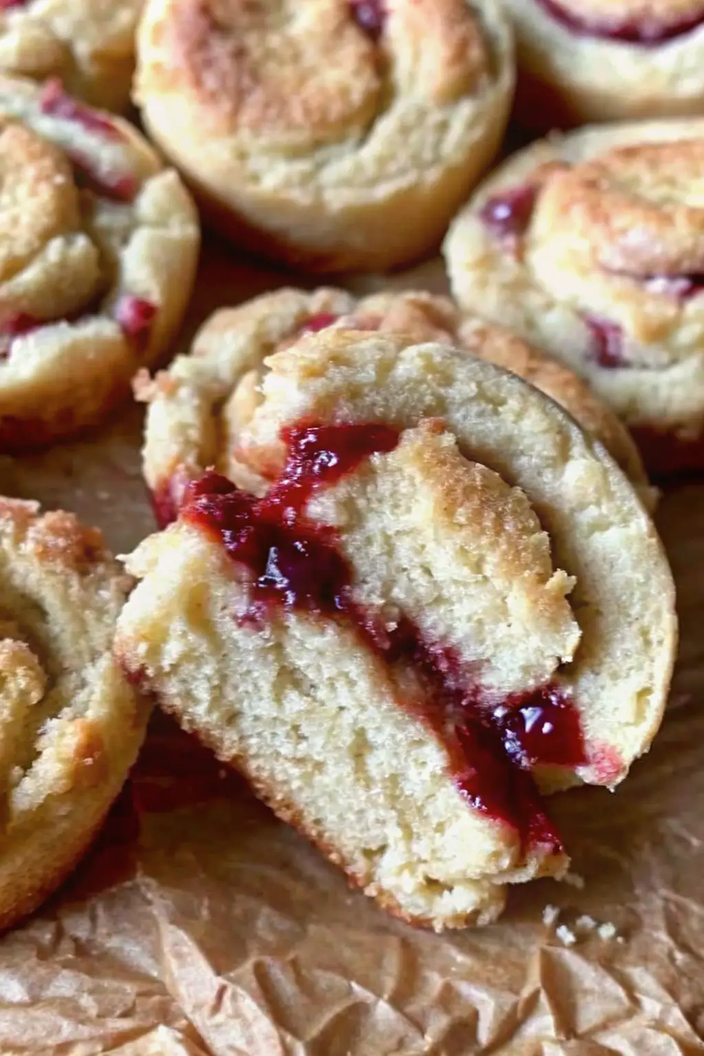Close-up of a strawberry almond flour cookie split in half showing soft interior and gooey jam layer