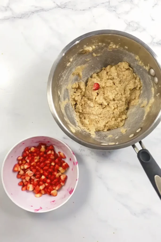 Step-by-step process of mixing strawberry almond flour cookie dough in ceramic bowls on a wooden counter