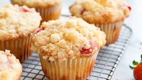 Freshly baked white chocolate strawberry muffin cooling on a rack