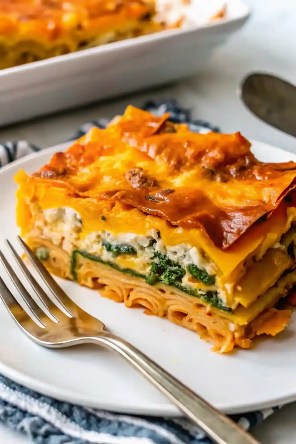 Layering butternut squash, spinach, and cheese for Invisible Butternut Squash Spinach and Mushroom Lasagna